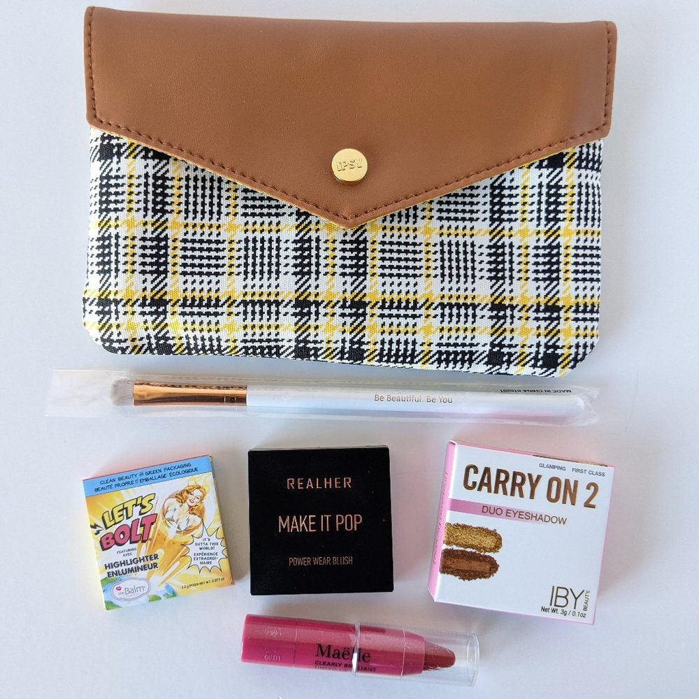 Yellow and black plaid IPSY bag with assorted makeup